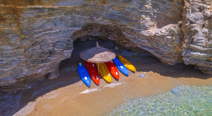 Colorful Kayaks Sheltered Beneath a Cliffside Cove on the Mediterranean Coast