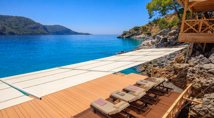 Shaded Waterfront Sundeck Overlooking a Calm Mediterranean Bay