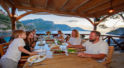 Family seaside dining prepared by a private chef on a quiet Mediterranean terrace