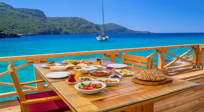 Private chef breakfast on a wooden sea deck overlooking a secluded Mediterranean bay