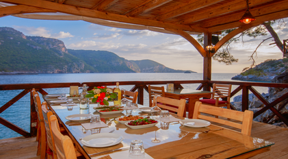 Seaside terrace dining setup prepared by a private chef overlooking a quiet Mediterranean bay