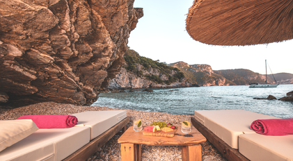 Private loungers set on a secluded rocky cove with coastal views