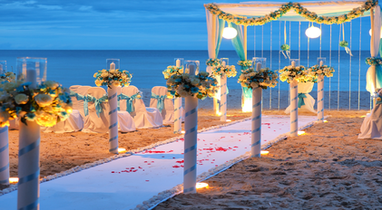 Evening beach wedding aisle prepared with floral columns by the Mediterranean