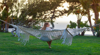 Quiet hammock relaxation overlooking a calm seaside garden at dusk