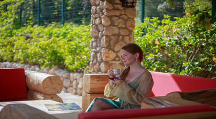 Slow morning coffee on a shaded stone veranda surrounded by lush greenery