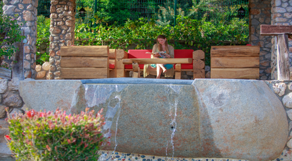 Quiet reading moment beside a stone veranda overlooking a cascading pool edge