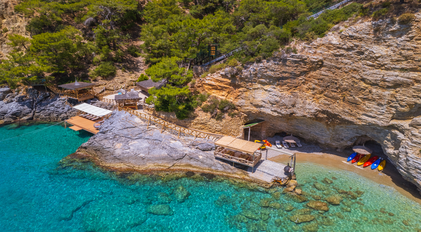 Aerial view of a secluded rocky bay with private decks on a Mediterranean peninsula