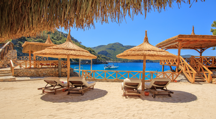 Secluded private bay beach with sunloungers and wooden decks on a Mediterranean peninsula