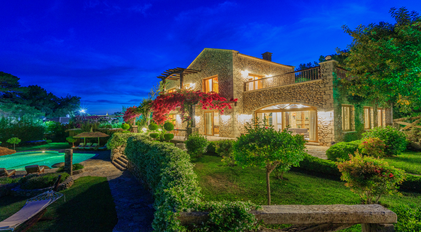 Night view of a stone villa surrounded by gardens on a secluded Mediterranean peninsula