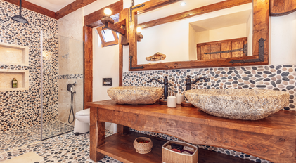 Bathroom with double stone basins and natural pebble wall textures