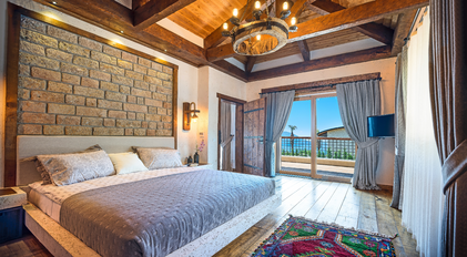 Master bedroom with stone headboard and sea-view terrace access