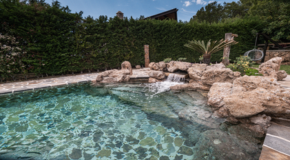 Rock pool with natural stone waterfall in the villa garden