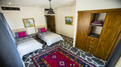 Rustic twin bedroom with stone flooring and handcrafted wooden accents