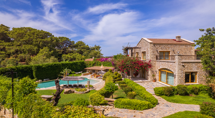 Aerial view of Villa Gemile with stone architecture, landscaped gardens and pool