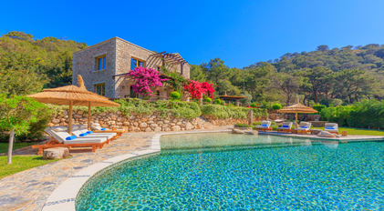Mediterranean stone villa with natural-style pool and vibrant bougainvillea gardens