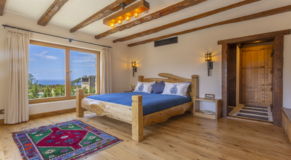 Master bedroom with sea-facing window and handcrafted wooden design elements