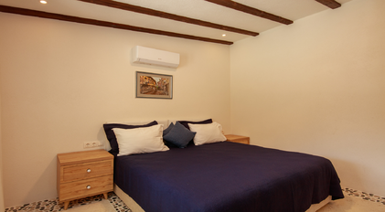 Minimal bedroom with wooden ceiling beams and soft natural lighting