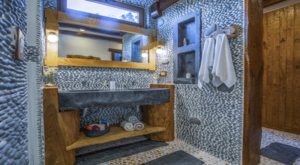 Rustic stone bathroom with handcrafted double vanity at Villa Gemile