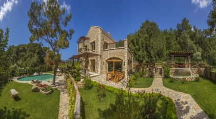 Panoramic stone villa overlooking landscaped gardens and a secluded forest-side pool