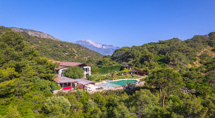 Aerial estate view of Villa Gökçe framed by forested hills and Mediterranean mountains