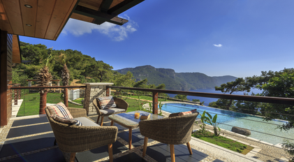 Balcony seating overlooking pool, mountains and the Mediterranean sea