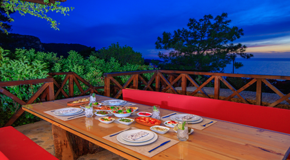 Evening terrace dining table with Mediterranean meze and coastal twilight views