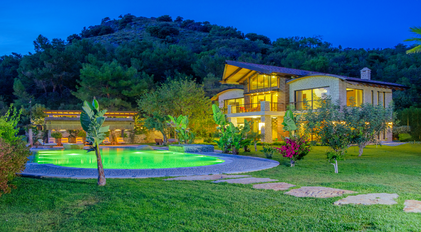 Night view of Villa Gokce with illuminated pool and stone architecture