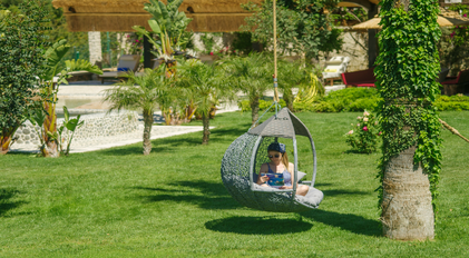 Hanging lounge chair surrounded by tropical greenery in a secluded garden space