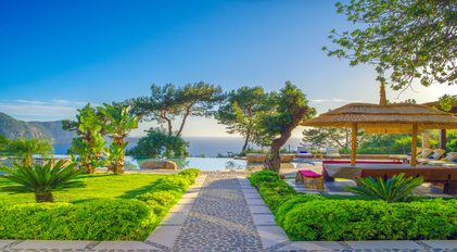 Garden pathway leading to infinity pool with Mediterranean sea views