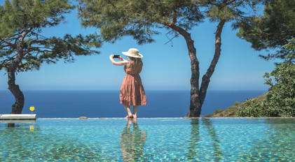 Infinity pool overlooking the deep blue Mediterranean and pine-framed horizon