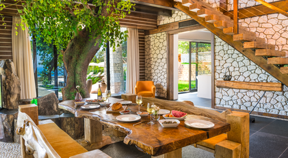 Interior dining space with organic wood table opening to the garden