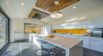 Bright modern kitchen with island counter and large garden-facing windows