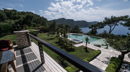 Terrace viewpoint overlooking private pool, gardens and a secluded Mediterranean bay