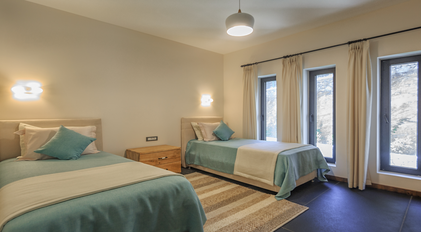 Bright twin bedroom with soft lighting and natural window views