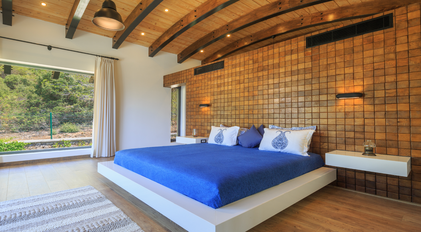 Minimal bedroom with wooden feature wall and expansive nature-facing window