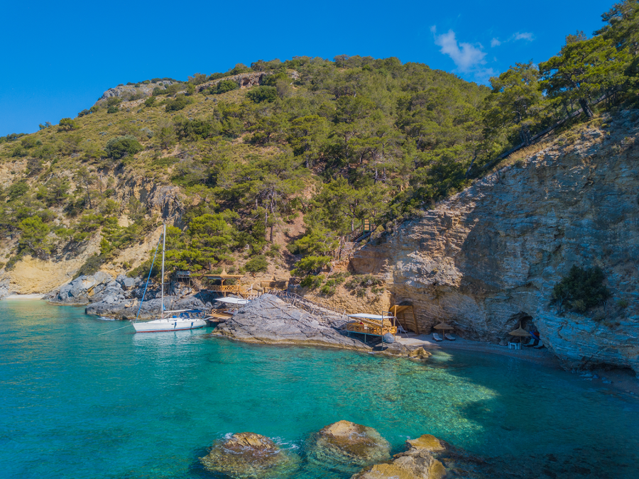 A secluded waterfront deck beside natural caves on a Mediterranean bay