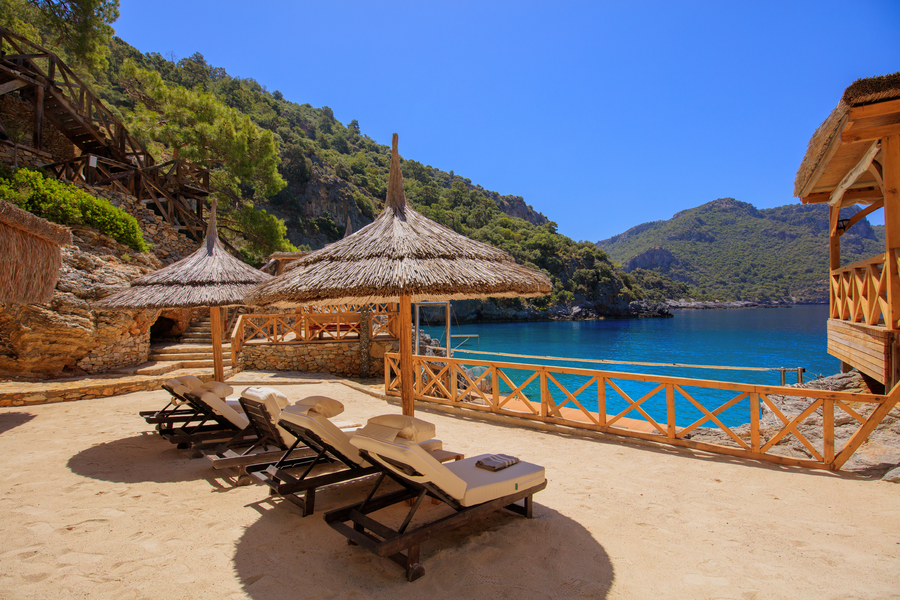 Waterfront Sundeck with Shaded Loungers Overlooking a Secluded Mediterranean Bay