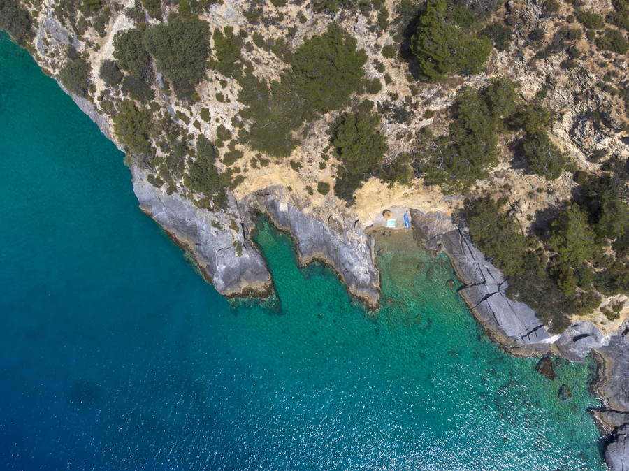 Aerial View of a Secluded Rocky Cove with Clear Shallow Waters