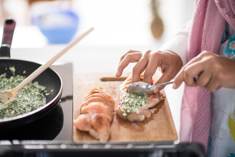 Private chef preparing a stuffed chicken dish in a minimalist kitchen setting