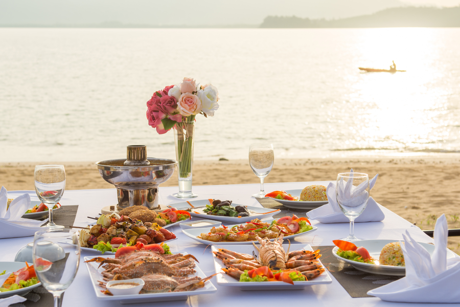 Seaside sunset dining prepared by a private chef with Mediterranean seafood dishes