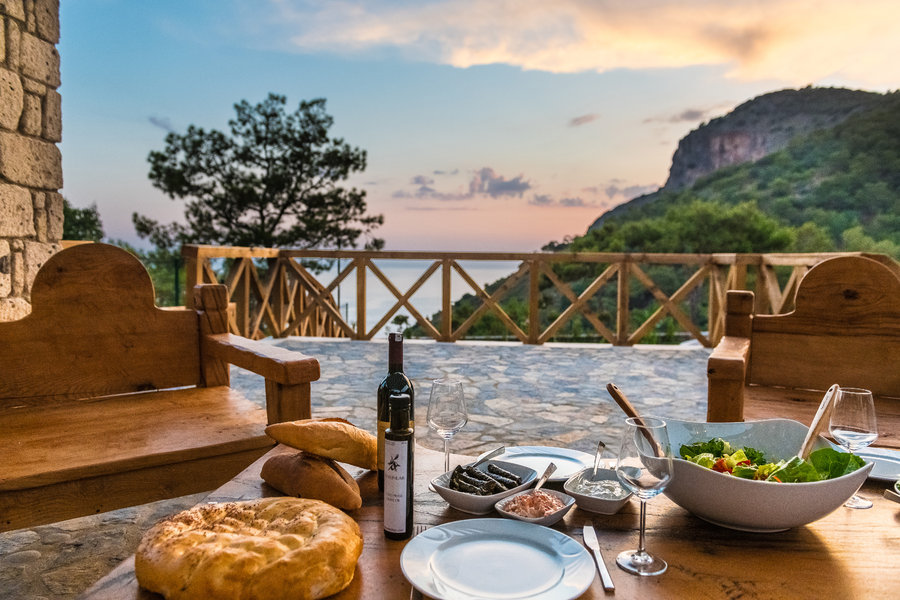 Sunset terrace dining prepared by a private chef overlooking a Mediterranean valley and sea