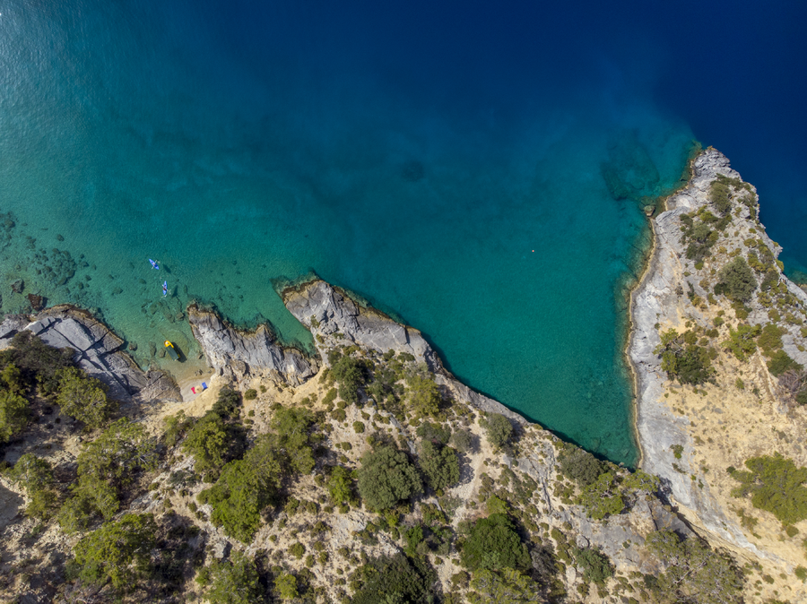 Aerial top-down view of a rugged Mediterranean coastline with a hidden micro cove