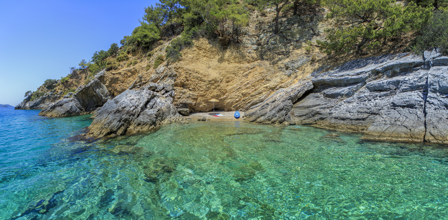 Secluded rocky cove with a tiny private beach on a Mediterranean peninsula