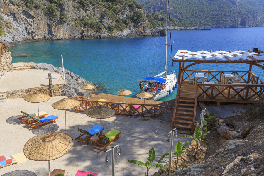 Beach deck and yacht access point overlooking a sheltered turquoise Mediterranean cove
