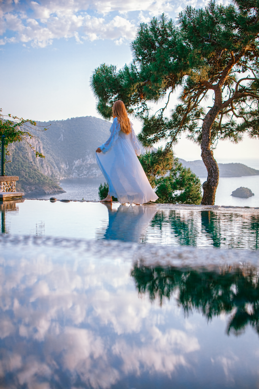 Bridal silhouette overlooking a serene private bay on a Mediterranean peninsula