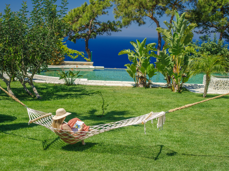Garden hammock facing an infinity pool and deep-blue Mediterranean sea