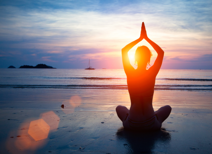 Meditative yoga silhouette at sunset by the tranquil sea
