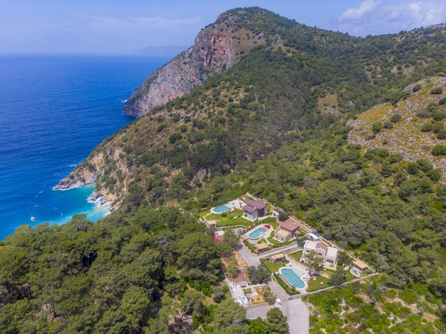 Aerial view of the estate below steep Mediterranean cliffs and turquoise sea