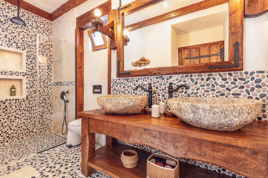 Bathroom with double stone basins and natural pebble wall textures