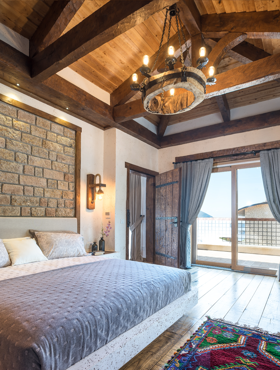 Rustic master bedroom with exposed beams and terrace access